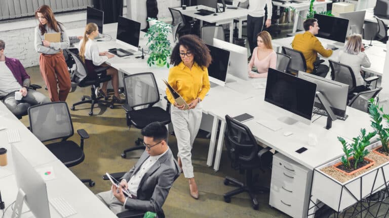 Busy office with employees at desks, walking around, etc